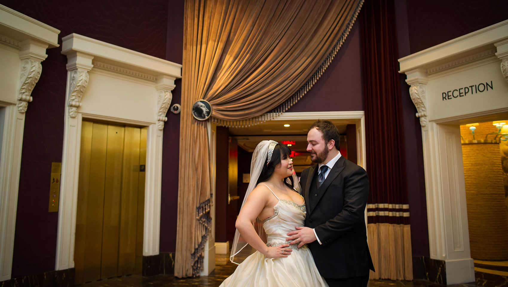 Bride and groom looking at each other in Kimpton Hotel Monaco Philadelphia’s lobby