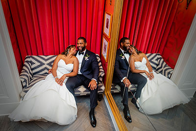 Bride and groom sitting next to each other on accent chair at Kimpton Hotel Monaco Philadelphia