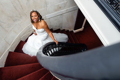 Bride in wedding dress walking up staircase