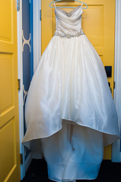 Bridal wedding dress hanging on door