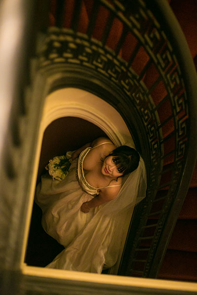 Bride looking up from the center of spiral staircase