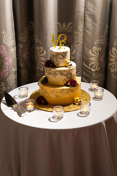 Tiered wedding cake with candles on table