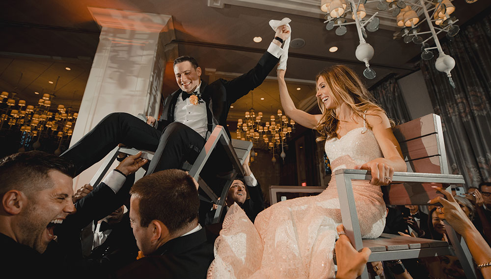 Leah and Rob on chairs for the hora