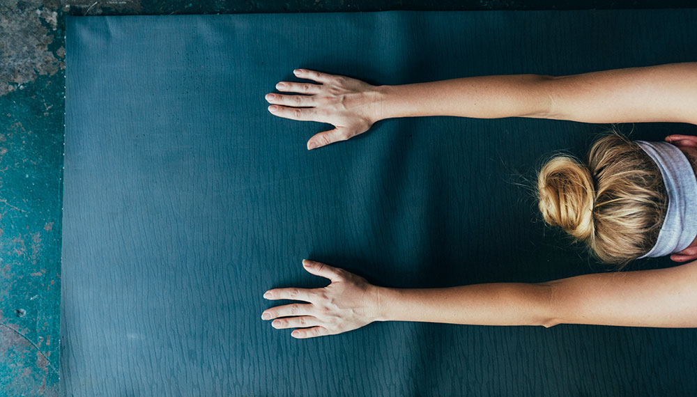 Woman stretching on yoga mat