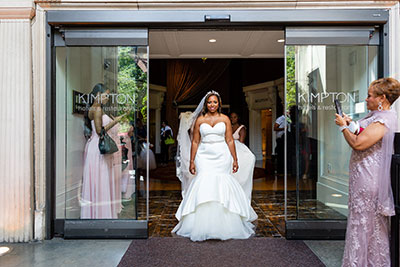 Bride exiting front entrance of Kimpton Hotel Monaco Philadelphia