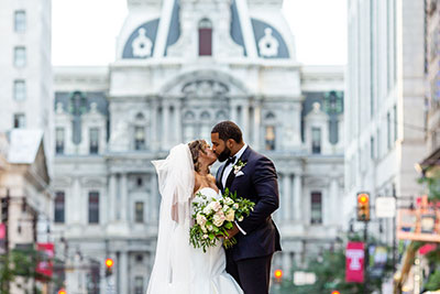 Bride and groom kissing on Broad Street in Philadelphia