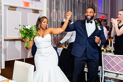 Bride and groom holding hands happily