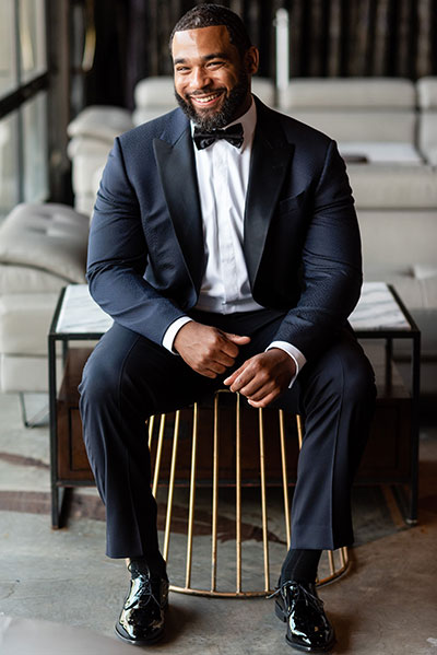 Groom smiling on chair at Kimpton Hotel Monaco Philadelphia