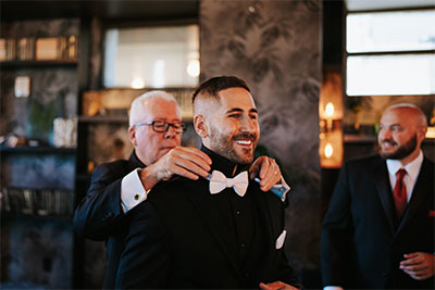 Groom getting his tie straightened