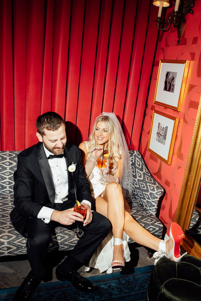 Newlyweds sharing cocktails on a sofa at Kimpton Hotel Monaco Philadelphia