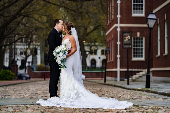 Bride and groom kissing on a cobblestone street in Philadelphia