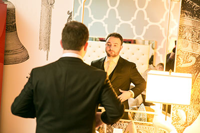 Groom in suit looking at himself in mirror