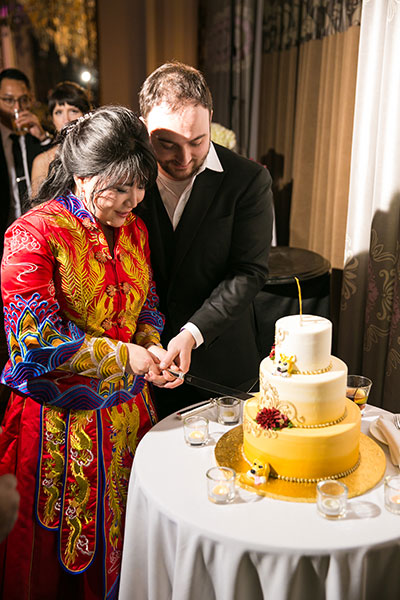 Bride and groom cutting cake together