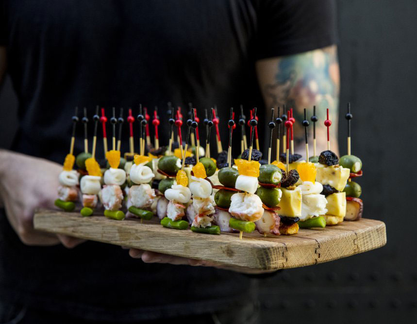 waiter serving passed hors’ doeurves on a wood tray