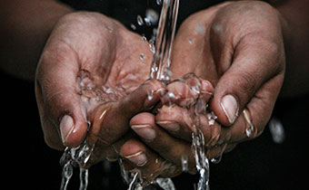 water coming out of faucet into hands
